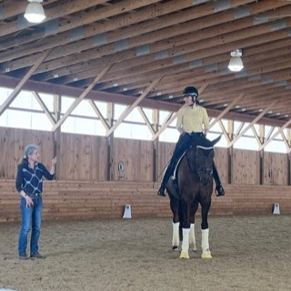 Felicitas talking with a rider on a dark horse